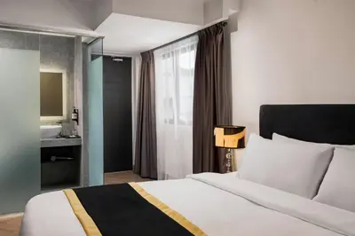 a bedroom with a bed and a bathroom with a sink at BRYQS Hotel in Kuala Lumpur