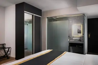a bedroom with a bed and a bathroom with a sink at BRYQS Hotel in Kuala Lumpur