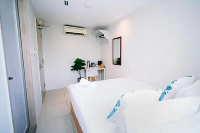 two beds in a room with white walls at Swing & Pillows - KL Pekeliling in Kuala Lumpur