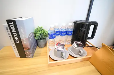 a table with bottles of water and a coffee maker at Swing & Pillows - KL Pekeliling in Kuala Lumpur
