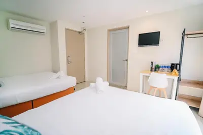 a bedroom with two beds and a tv at Swing & Pillows - KL Pekeliling in Kuala Lumpur