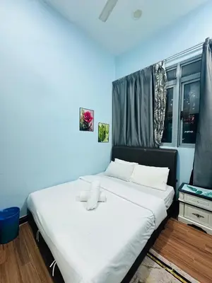 a bedroom with a large bed with white sheets at Taragon Apartment - KL ,Malaysia in Kuala Lumpur