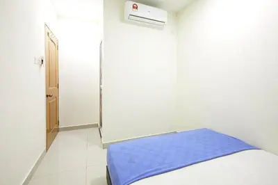 a white room with a bed with a blue blanket at Hotel 3Winz Chow Kit Kuala Lumpur in Kuala Lumpur