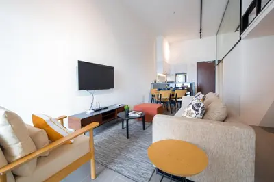 a living room with a couch and a tv at Establishment Bangsar By Sleepy Bear in Kuala Lumpur
