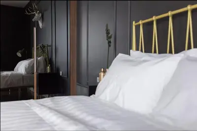 a bedroom with a bed with white sheets at Anggun Residence KLCC By Sleepy Bear in Kuala Lumpur