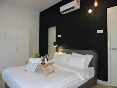 a bedroom with a bed with a black wall at Arte Plus By Sleepy Bear in Batu Empat
