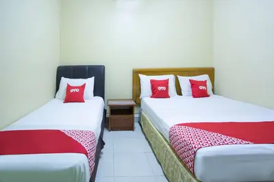 two beds in a room with red pillows at Hotel O Perfect Class Hotel in Kuala Lumpur