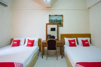 two beds in a room with red pillows at Hotel O Perfect Class Hotel in Kuala Lumpur