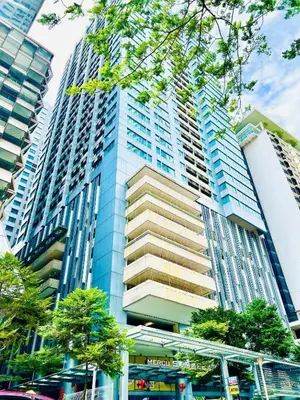 a tall blue building with a bus in front of it at Valencia Dorm at Mercu Summer Suites KLCC in Kuala Lumpur
