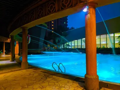 a swimming pool at night in front of a building at Serviced Apartments at Times Square Kuala Lumpur by Robinsons in Kuala Lumpur