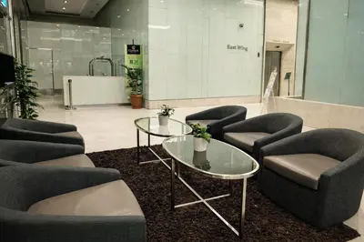 a waiting area with chairs and tables in a lobby at Cormar Suites Kuala Lumpur in Kuala Lumpur