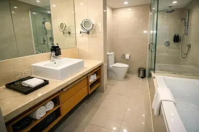 a bathroom with a sink and a shower and a toilet at Cormar Suites Kuala Lumpur in Kuala Lumpur