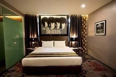 a bedroom with a bed with a poster of the beatles at Kingston Hotel 3 - Kuala Lumpur in Kuala Lumpur