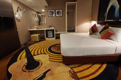 a hotel room with a bed with a guitar on the floor at Kingston Hotel 3 - Kuala Lumpur in Kuala Lumpur