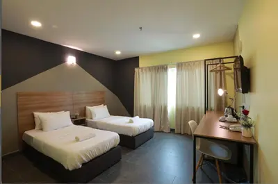 a hotel room with two beds and a desk at T-hotel Mont Kiara in Kuala Lumpur