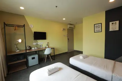 a hotel room with two beds and a desk at T-hotel Mont Kiara in Kuala Lumpur