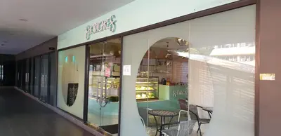 a store front with glass windows and a table and chairs at Infinity KLCC Pool at M City Ampang in Kuala Lumpur