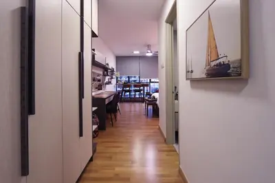 a hallway leading to a dining room with a sail boat on the wall at Lily and Loft - KL Gateway Bangsar LRT, WIFI, Netflix in Kuala Lumpur