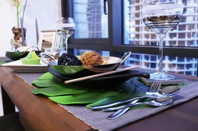 a table with a plate of food and a glass of wine at Lily and Loft - KL Gateway Bangsar LRT, WIFI, Netflix in Kuala Lumpur