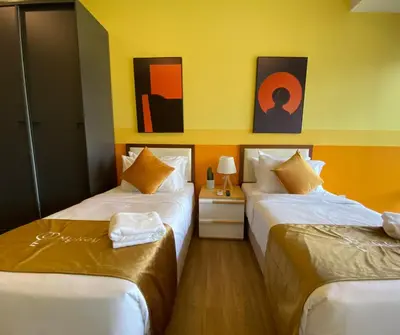 two beds in a room with paintings on the wall at Ceylonz Seasonal Suites in Kuala Lumpur