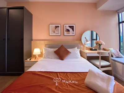 a bedroom with a bed and a desk and a mirror at Ceylonz Starlight Suites Bukit Bintang in Kuala Lumpur