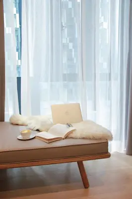 a laptop computer sitting on a bed with a book at Star Suites KLCC in Kuala Lumpur