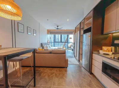 a kitchen and living room with a couch and a table at Scarletz Suites KLCC in Kuala Lumpur