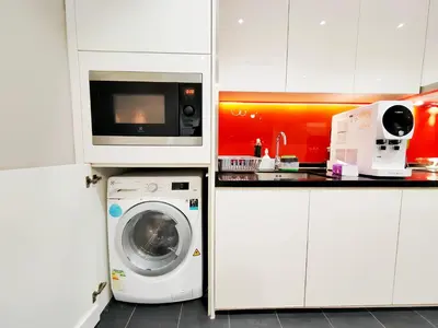 a kitchen with a washing machine and a microwave at Arcoris Mont Kiara in Kuala Lumpur