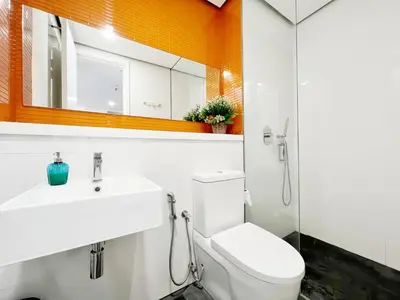 a bathroom with a toilet and a sink and a mirror at Arcoris Mont Kiara in Kuala Lumpur