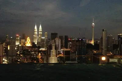 a view of a city skyline at night at KLCC Regalia Suites Infinity Pool Kuala Lumpur in Kuala Lumpur
