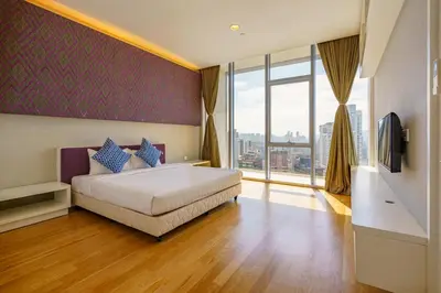 a bedroom with a bed and a large window at Yemala Suites at Platinum KLCC in Kuala Lumpur