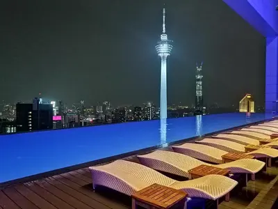 a row of chairs on the roof of a building at night at Yemala Suites at Platinum KLCC in Kuala Lumpur