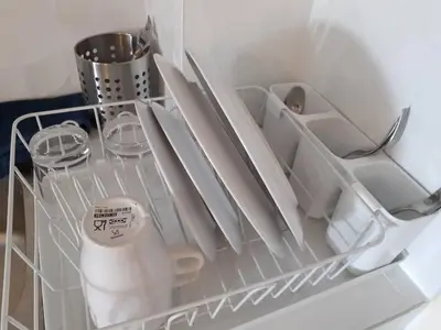 a white dish rack with utensils in a refrigerator at Omar's Place 2 in Kuala Lumpur