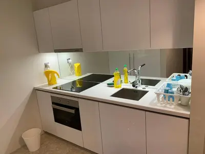 a kitchen with white cabinets and a sink at KLCC City SkySuites in Kuala Lumpur