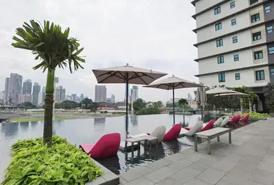 a row of chairs and umbrellas in front of a building at MyCrib Opus Recidence 3 bedroom BBintang in Kuala Lumpur