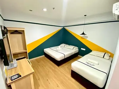 two beds in a room with a colorful wall at Seeds Hotel PV128 Setapak in Kuala Lumpur