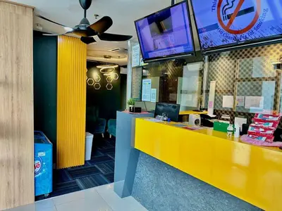 a restaurant with a yellow counter and a tv at Seeds Hotel PV128 Setapak in Kuala Lumpur