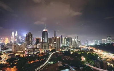 a city lit up at night with traffic at Regalia Residence KLCC View by iLuxHome in Kuala Lumpur