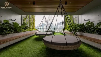 two swings in a room with grass and plants at Ceylonz Suites Kuala Lumpur, Roam in Kuala Lumpur