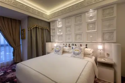 a bedroom with a large white bed with pillows at arte by Thomas Chan in Kuala Lumpur