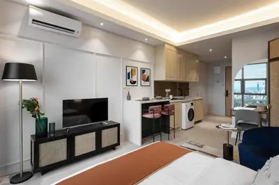 a bedroom with a bed and a living room and a kitchen at AMI Suites - Arte Mont Kiara in Kuala Lumpur