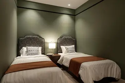 two beds in a room with green walls at AMI Suites - Arte Mont Kiara in Kuala Lumpur
