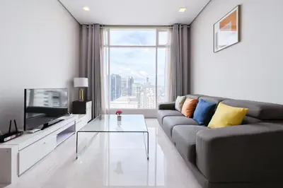 a living room with a couch and a glass coffee table at Soho Suites KLCC by GuestHouse in Kuala Lumpur