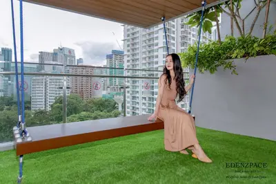 a woman in a dress sitting on a swing at Ceylonz Suites by EdenZpace in Kuala Lumpur