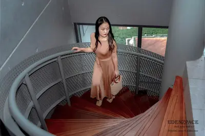 a woman in a dress walking down a staircase at Ceylonz Suites by EdenZpace in Kuala Lumpur