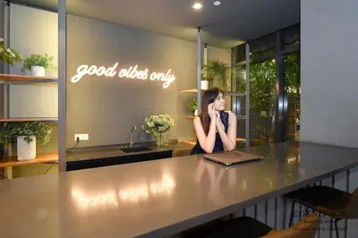 a woman sitting at a counter in a kitchen at Ceylonz Suites by EdenZpace in Kuala Lumpur