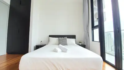 a bedroom with a large white bed with two books on it at KLGateway Premium Residence Mid Valley in Kuala Lumpur