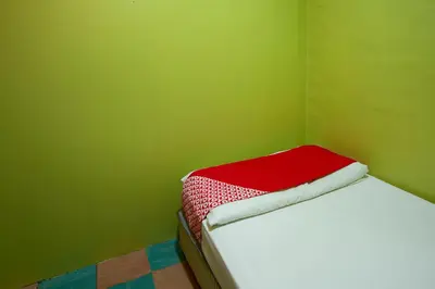 a small room with a bed in a green wall at SPOT ON 90137 Casavilla Hotel Pudu in Kuala Lumpur