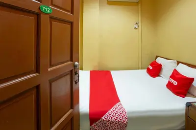 a small room with a bed with red and white pillows at SPOT ON 90137 Casavilla Hotel Pudu in Kuala Lumpur