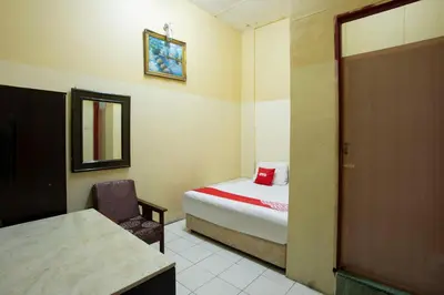 a room with a bed and a chair and a door at SPOT ON 90137 Casavilla Hotel Pudu in Kuala Lumpur